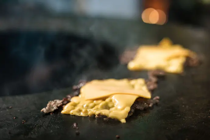 Cheddar die smelt op vlees van de vuurschaal