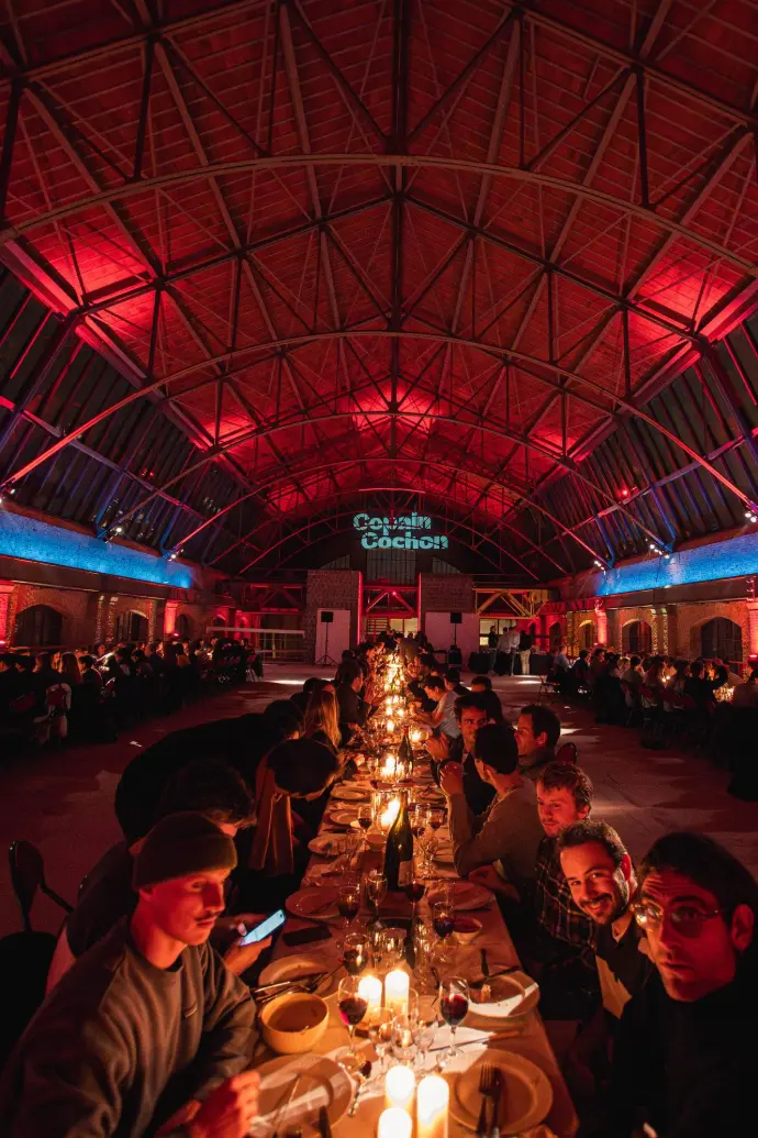 Lange tafel in rood licht onder het glazen dak van een hal