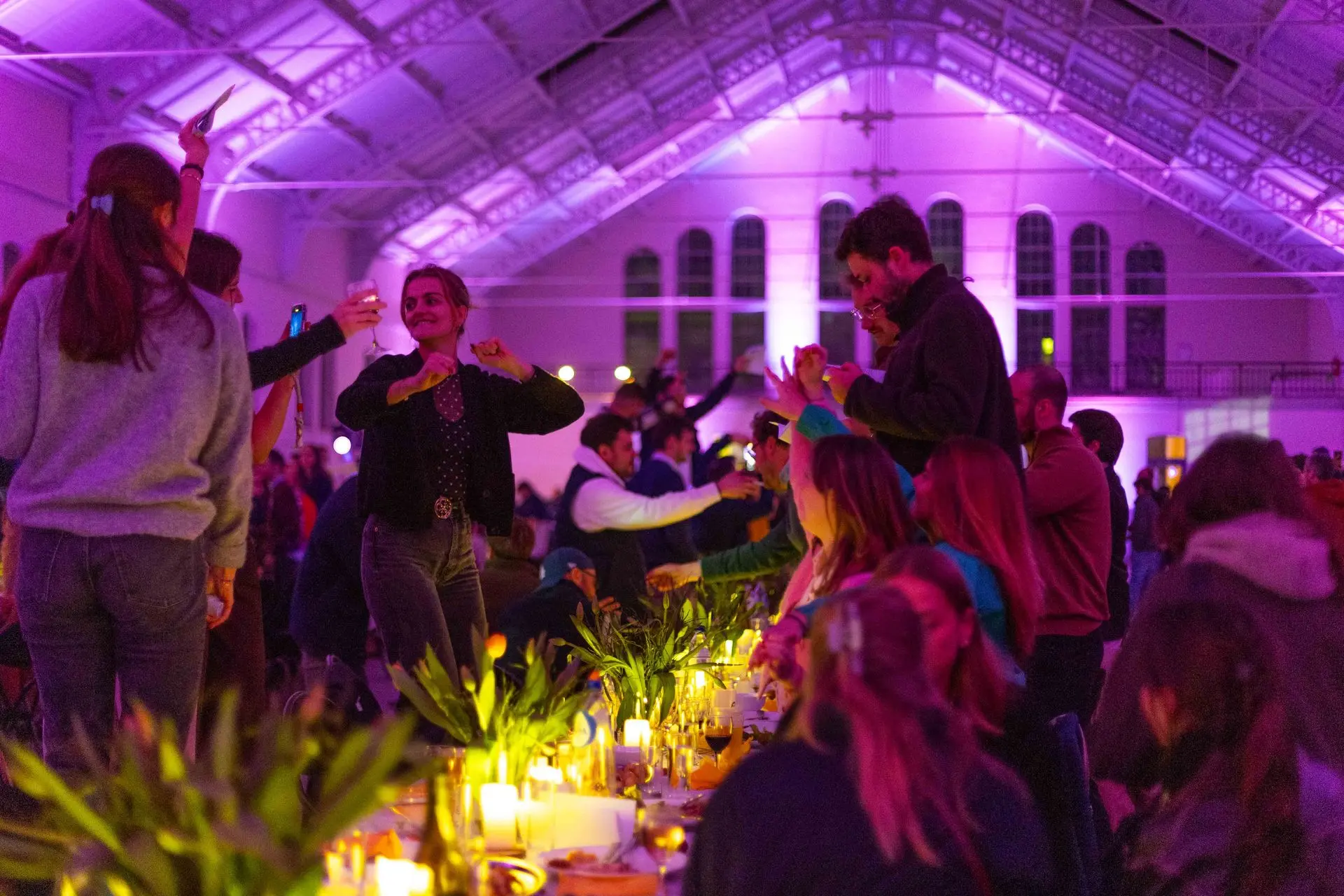 Gasten aan tafel in violet licht tijdens een bijzonder diner